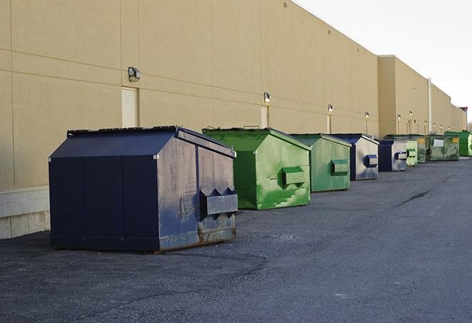 a row of yellow and blue dumpsters at a construction site in Apollo Beach FL